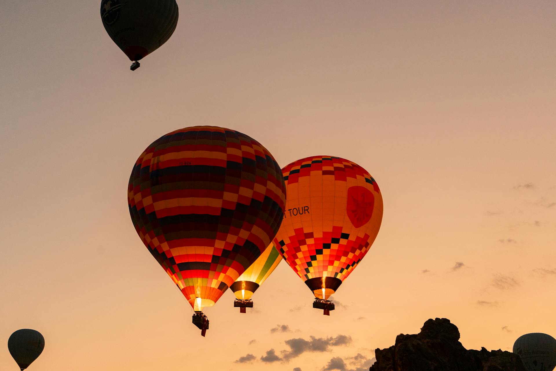 Colorful hot air balloons flying at sunrise in Cappadocia, Turkey – Conmigo Travel Agency