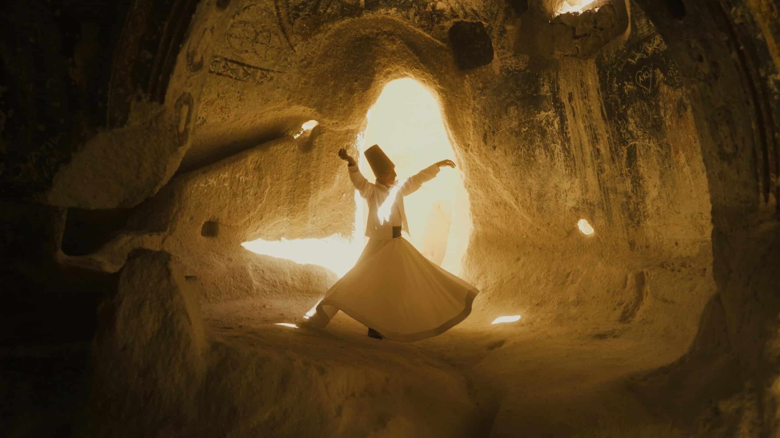 Whirling dervish performing inside an ancient cave in Cappadocia, Turkey